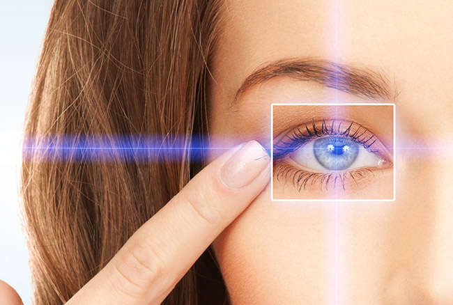 Woman pointing at left eye. Eye has a laser going toward it.