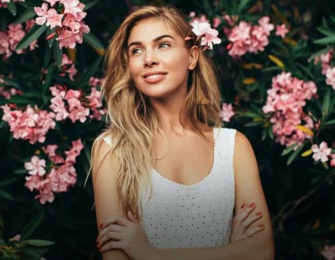 Woman in front of wall of flowers