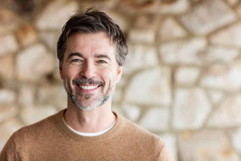 Middle-aged man with stone background.