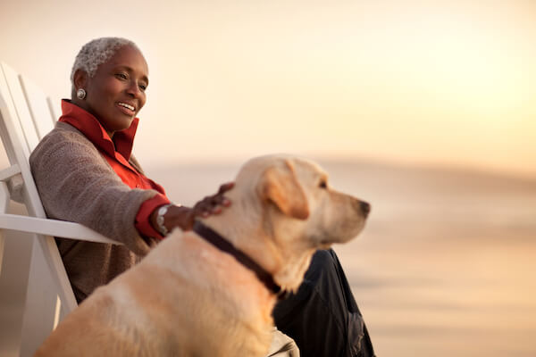 Senior woman at sunset in chair with dog.