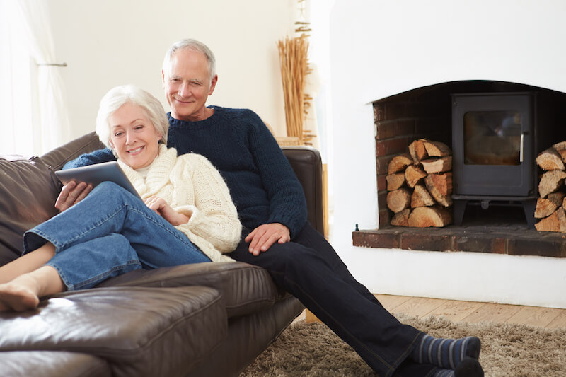 Senior couple on the couch looking at tablet