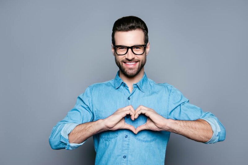 hipster in glasses making a heart with his hands