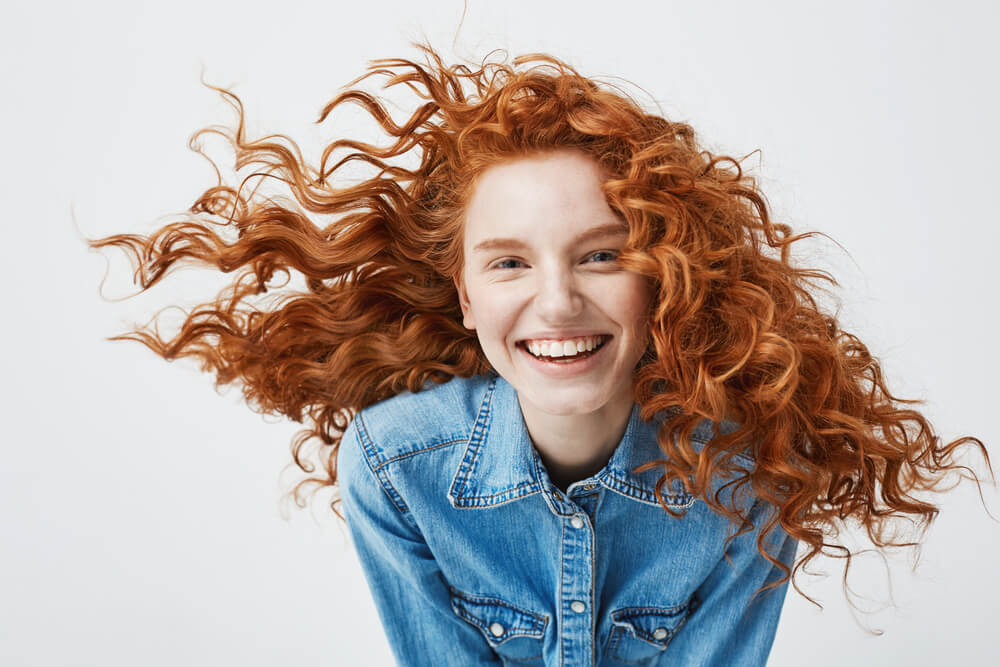 Smiling young girl with bright red hair